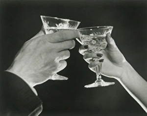 Man and woman toasting martini glasses, close up of hands Man and woman toasting martini glasses, close up of hands