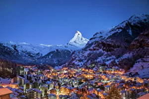 The Matterhorn mountain peak over Zermatt city at night, Switzerland The Matterhorn mountain peak over Zermatt city at night, Switzerland