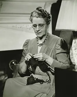 Mature woman knitting in living room, (B&W) Mature woman knitting in living room, (B&W)
