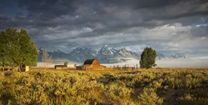 <b class=qtipBold><figcaption>Mormon Row Sunrise</figcaption></b><br>Storm clouds clear over Grand Teton National Park as the sun rises over Mormon Row during the beginning of autumn.<br><em>© 2014 Chase Dekker Wild-Life Images</em> Mormon Row Sunrise