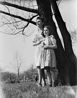 Mother and daughter (8-9) standing under tree Mother and daughter (8-9) standing under tree