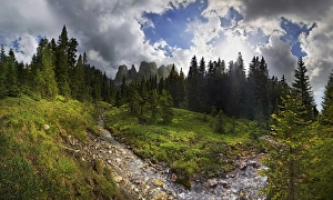 Mountain forest with a small creek, Geisler Group, Odle Mountains at Ranui, Santa Maddalena, Villnoess or Funes Valley Mountain forest with a small creek, Geisler Group, Odle Mountains at Ranui, Santa Maddalena, Villnoess or Funes Valley