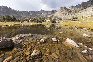 Mountain lake with large rocks and Beehive Basin in background, Big Sky, Montana, USA Mountain lake with large rocks and Beehive Basin in background, Big Sky, Montana, USA