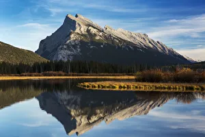 Mountain lake reflecting mountain at sunset with blue sky and clouds, Banff National Park Mountain lake reflecting mountain at sunset with blue sky and clouds, Banff National Park