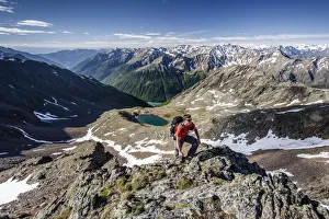 Mountaineer during the ascent of Mt Grawand , Ortler Alps at the back, Val Senales below with the Vernagt Reservoir, Meraner Land area, Merano, Meran region, South Tyrol, Italy Mountaineer during the ascent of Mt Grawand , Ortler Alps at the back, Val Senales below with the Vernagt Reservoir, Meraner Land area, Merano, Meran region, South Tyrol, Italy