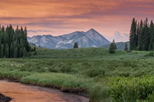 <b class=qtipBold><figcaption>Mt Crested Butte</figcaption></b><br>Mount Crested Butte at sunrise with color reflected into river<br><em>© Russell Burden</em> Mt Crested Butte