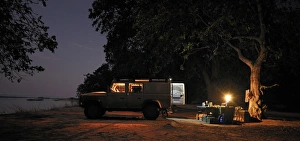 Off-road car and evening campsite alongside the Zambezi River, Mana Pools, Zambezi Valley Off-road car and evening campsite alongside the Zambezi River, Mana Pools, Zambezi Valley