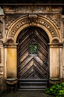 An old carved wooden door with an ornate frame with latin inscriptions An old carved wooden door with an ornate frame with latin inscriptions