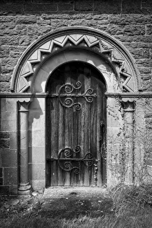 Old church door with stone arch and ornate hinges Old church door with stone arch and ornate hinges