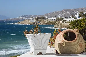 Old flower pots on foreground and Mykonos town and Aegean sea in the background, Cyclades, Greece Old flower pots on foreground and Mykonos town and Aegean sea in the background, Cyclades, Greece