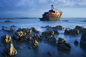 Old shipwreck long exposure on the rocks at sunset - Cape LAgulhas South Africa Old shipwreck long exposure on the rocks at sunset - Cape LAgulhas South Africa