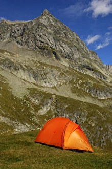 Orange-coloured mountain tent below the summit of Wiwanni Mountain in the Pennine Alps Orange-coloured mountain tent below the summit of Wiwanni Mountain in the Pennine Alps