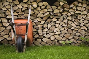 Orange wheelbarrow propped up against stacked firewood, Quebec City, Quebec Province Orange wheelbarrow propped up against stacked firewood, Quebec City, Quebec Province