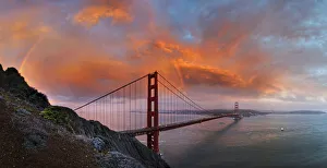 Panoramic view of the Golden Gate Bridge with a rainbow at sunset and orange-glowing storm clouds, San Francisco Panoramic view of the Golden Gate Bridge with a rainbow at sunset and orange-glowing storm clouds, San Francisco