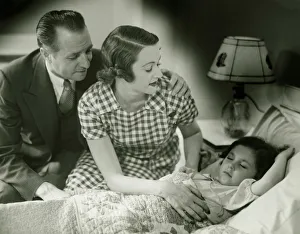 Parents looking at sleeping daughter (6-7), (B&W) Parents looking at sleeping daughter (6-7), (B&W)