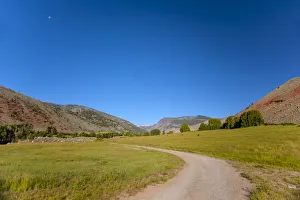 Path leading to valley in far distance with red rocky hills on side, Wyoming, USA Path leading to valley in far distance with red rocky hills on side, Wyoming, USA