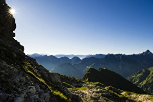 Peaks of the Allgau Alps in steplike arrangement in the early morning with a sun star Peaks of the Allgau Alps in steplike arrangement in the early morning with a sun star