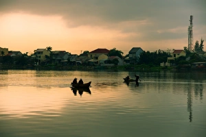 Two people on the boat in early morning in Hoian Two people on the boat in early morning in Hoian