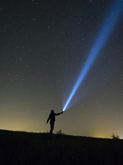 Person lighting the sky with a flashlight Person lighting the sky with a flashlight