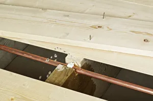 Pipe with hole in exposed under floor boards Pipe with hole in exposed under floor boards
