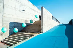Poetic stop motion picture of green balloons following each other going up on stairs in a Poetic stop motion picture of green balloons following each other going up on stairs in a