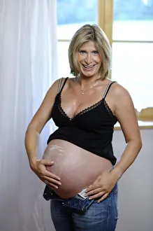 Pregnant woman applying lotion on her belly Pregnant woman applying lotion on her belly