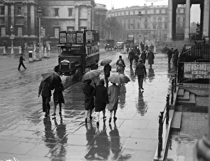 <b class=qtipBold><figcaption>Rainy Day In London</figcaption></b><br>circa 1930: A rainy day in Trafalgar Square, London. Part of the National Gallery is in the background and an open topped bus carrying adverts is parked by the kerb. (Photo by Fox Photos/Getty Images) Rainy Day In London