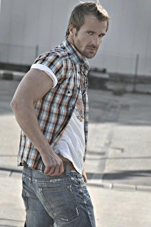 Rebellious man wearing jeans and a plaid shirt at a gas station, turning round Rebellious man wearing jeans and a plaid shirt at a gas station, turning round