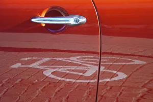 Red car door reflecting a pictogram from a bicycle lane Red car door reflecting a pictogram from a bicycle lane