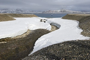Remnants of snow surrounding a stream of meltwater, expedition cruise ship MS Quest at Remnants of snow surrounding a stream of meltwater, expedition cruise ship MS Quest at
