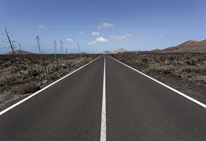 Road through volcanic landscape, near Mancha Blanca, Lanzarote, Canary Islands, Spain Road through volcanic landscape, near Mancha Blanca, Lanzarote, Canary Islands, Spain