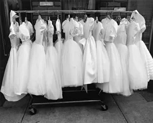 Images Dated 9th June 2004: Row of white dresses hanging on rack
