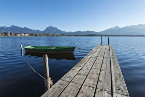 Rowing boat with jetty on the shore of Hopfensee Lake near Fuessen, Ostallgaeu region Rowing boat with jetty on the shore of Hopfensee Lake near Fuessen, Ostallgaeu region