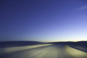 Sand road through dunes, lit by headlights, night (blurred motion) Sand road through dunes, lit by headlights, night (blurred motion)