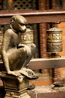 Sculpture of a seated monkey and prayer mills in the Golden Temple, a Buddhist temple Sculpture of a seated monkey and prayer mills in the Golden Temple, a Buddhist temple