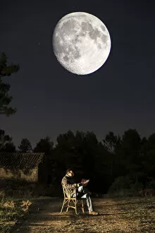 Dreamlike Gallery: Seated man reading a book in the moonlight