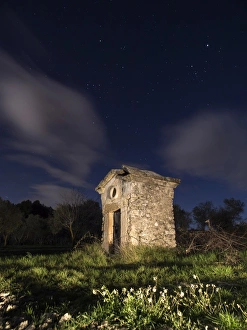 Shed a waterhole, abandoned medieval building, seen at night in the field Shed a waterhole, abandoned medieval building, seen at night in the field