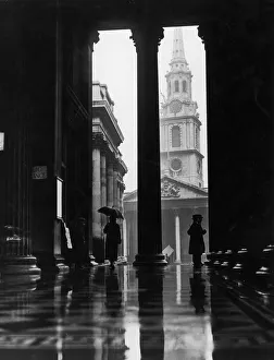 <b class=qtipBold><figcaption>Sheltering From Rain</figcaption></b><br>February 1928: People sheltering from the rain under the portico of the National Gallery in London. The church of St-Martin-in-the-Fields can be seen in the background. (Photo by Fox Photos/Getty Images) Sheltering From Rain