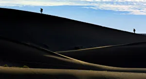 Silhouettes of people climbing a dune, desert landscape, Namib, Hardap Region, Namibia Silhouettes of people climbing a dune, desert landscape, Namib, Hardap Region, Namibia