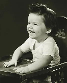 Smiling girl (2-3) sitting in high chair, (B&W) Smiling girl (2-3) sitting in high chair, (B&W)