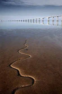 Snake like stream flowing to river with bridge Snake like stream flowing to river with bridge