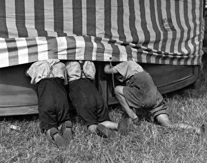 <b class=qtipBold><figcaption>Sneak Preview</figcaption></b><br>11th August 1937: Three schoolboys take an anauthorised look inside one of the tents at Crayford Fair, during their summer holidays. (Photo by Derek Berwin/Fox Photos/Getty Images) Sneak Preview