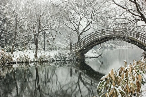 Snowscape of wooden arch bridge over pond in Maojiabu village, Hangzhou, Zhejiang, China Snowscape of wooden arch bridge over pond in Maojiabu village, Hangzhou, Zhejiang, China