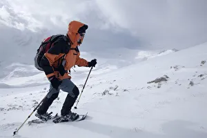 Snowshoe walker ascending Neunerspitze peak, Dolomites, South Tyrol, Italy, Europe Snowshoe walker ascending Neunerspitze peak, Dolomites, South Tyrol, Italy, Europe