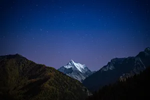 Snowy mountain peak at night with the stars Snowy mountain peak at night with the stars