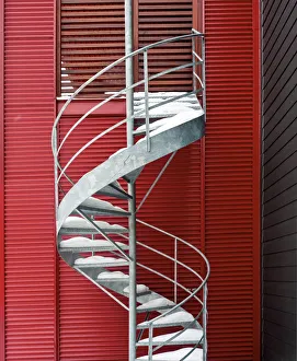 <b class=qtipBold><figcaption>Spiral staircase</figcaption></b><br>Silver aluminum spiral staircase, lightly covered with fresh-fallen snow, seen against a bright red sided building.<br><em>© marianna armata</em> Spiral staircase
