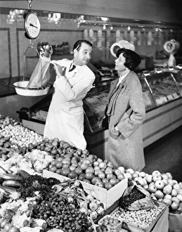 Store clerk weighing tomatoes for client (B&W) Store clerk weighing tomatoes for client (B&W)