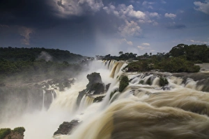 <b class=qtipBold><figcaption>Storm clouds over the Iguazu Falls</figcaption></b><br>Iguazu falls, one of the new seven wonders of nature. UNESCO World Heritage site.Iguassu Falls is the largest series of waterfalls on the planet, located in Brazil, Argentina, and Paraguay. View from the argentinian side. Storm clouds over the Iguazu Falls