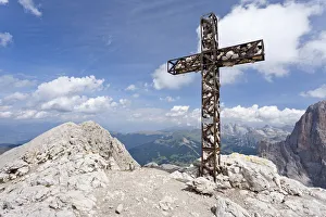 Summit cross on Plattkofel Mountain, looking towards the Odle Mountain Group, Dolomites Summit cross on Plattkofel Mountain, looking towards the Odle Mountain Group, Dolomites