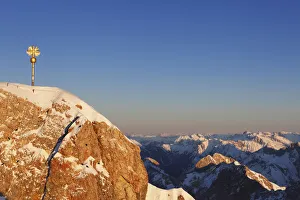 Summit cross on Zugspitze Mountain in the evening light, looking towards the east Summit cross on Zugspitze Mountain in the evening light, looking towards the east